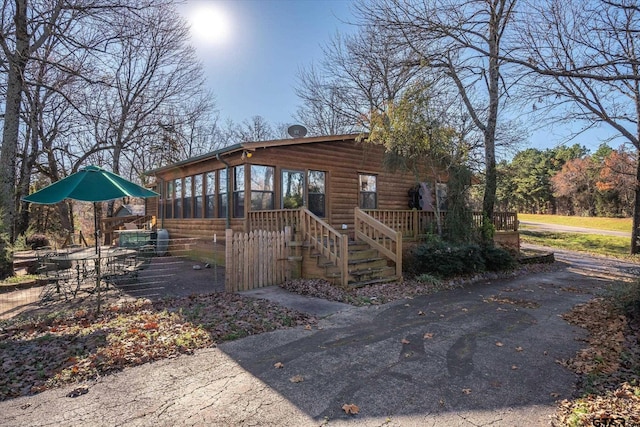 view of outbuilding with stairs and a sunroom