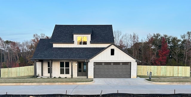 modern farmhouse style home with a porch, a front yard, and a garage