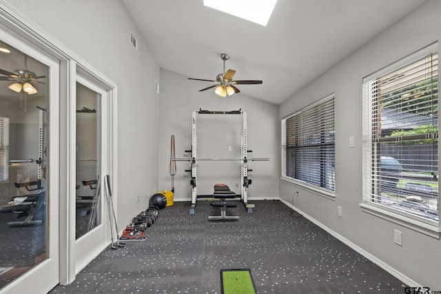 exercise room featuring ceiling fan, vaulted ceiling, and carpet