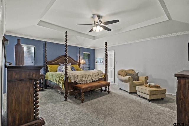 carpeted bedroom with ceiling fan, a tray ceiling, and ornamental molding