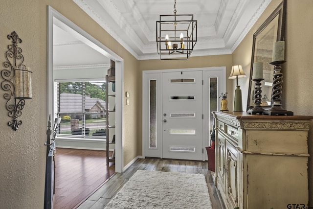 entrance foyer featuring a raised ceiling, wood-type flooring, crown molding, and a chandelier