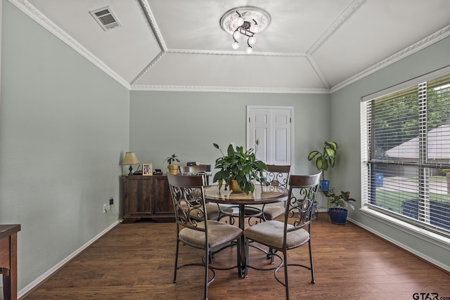 dining space featuring vaulted ceiling, dark hardwood / wood-style floors, an inviting chandelier, and ornamental molding