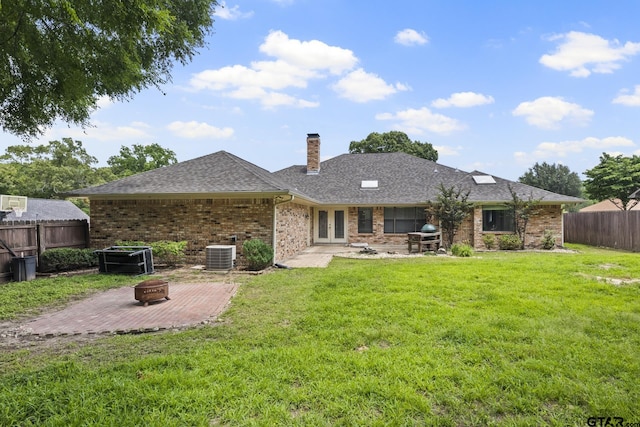 back of house with central air condition unit, an outdoor fire pit, a lawn, and a patio