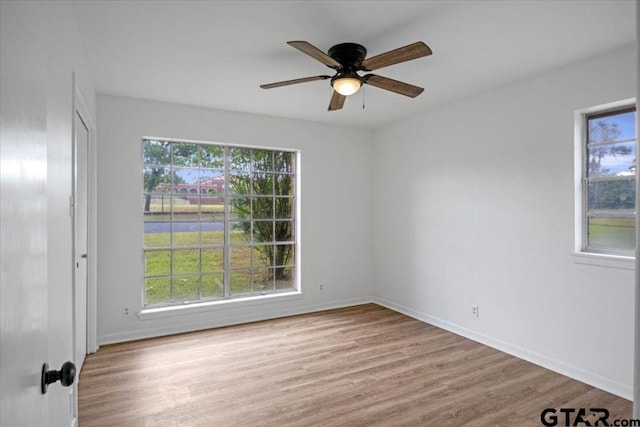 empty room featuring baseboards, ceiling fan, and wood finished floors