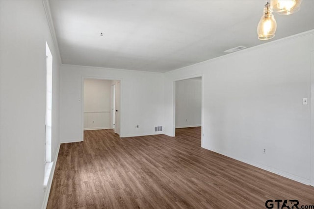 spare room with visible vents, baseboards, and wood finished floors