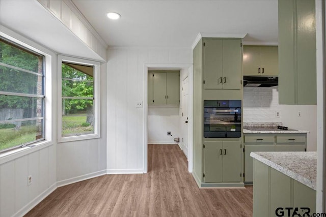 kitchen featuring light wood-style flooring, green cabinetry, exhaust hood, and black appliances