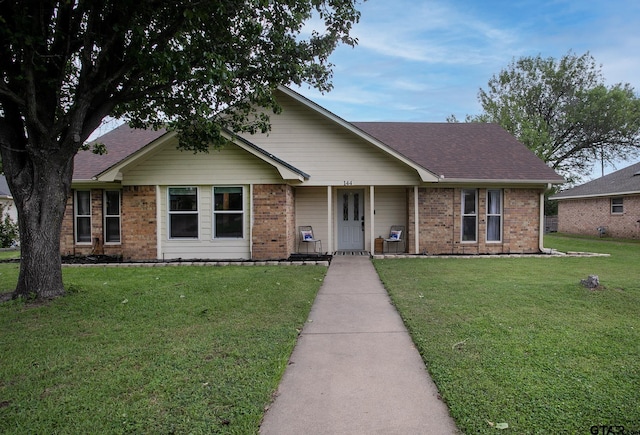 ranch-style house featuring a front yard, roof with shingles, a porch, and brick siding