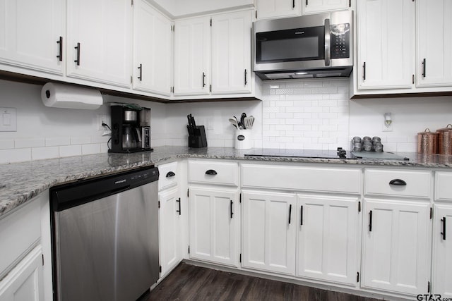 kitchen with stainless steel appliances, white cabinets, decorative backsplash, and light stone countertops