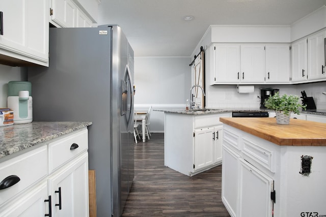 kitchen with a sink, dark wood-style flooring, butcher block countertops, and white cabinets