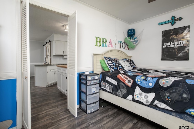 bedroom featuring crown molding, dark wood-type flooring, and a sink