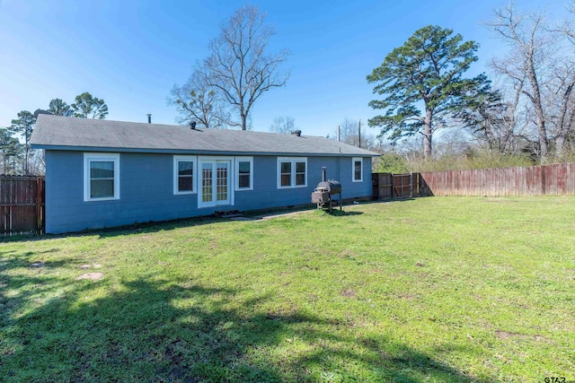 back of property with a lawn and a fenced backyard