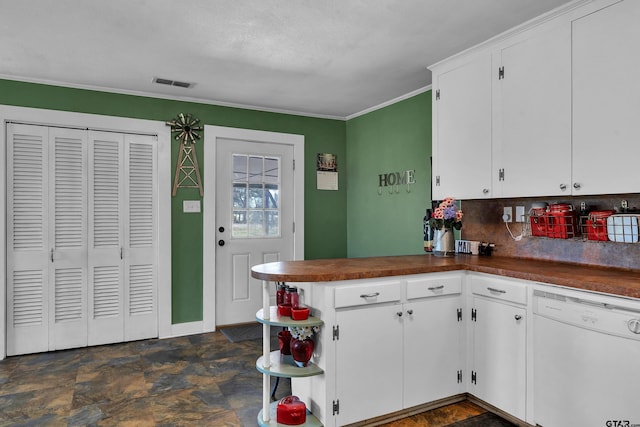 kitchen with dark countertops, visible vents, white dishwasher, and stone finish flooring