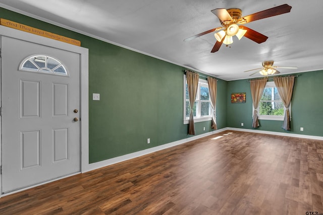 foyer entrance with ornamental molding, baseboards, and wood finished floors