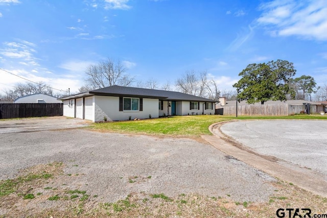 ranch-style house with a garage and a front yard