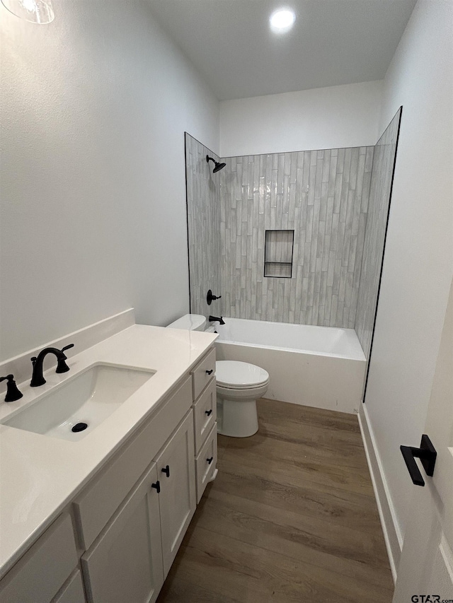 full bathroom featuring wood finished floors, toilet, tub / shower combination, and vanity