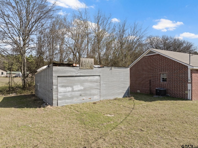 view of outbuilding with central air condition unit and a lawn