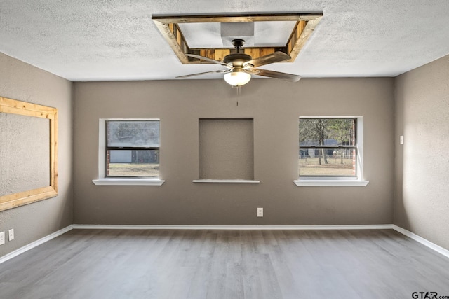 spare room featuring ceiling fan, wood-type flooring, and a textured ceiling