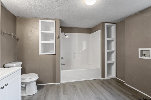 full bathroom featuring hardwood / wood-style floors, bathtub / shower combination, vanity, toilet, and a textured ceiling