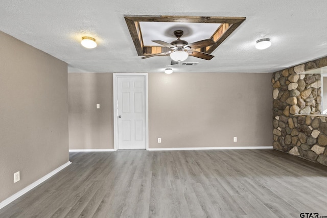 unfurnished living room with ceiling fan, hardwood / wood-style flooring, and a textured ceiling