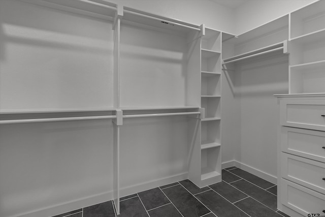 spacious closet featuring dark tile patterned flooring