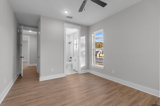 unfurnished bedroom with hardwood / wood-style flooring, ceiling fan, and connected bathroom