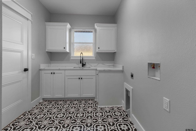 laundry room with sink, light tile patterned flooring, hookup for a washing machine, cabinets, and hookup for an electric dryer