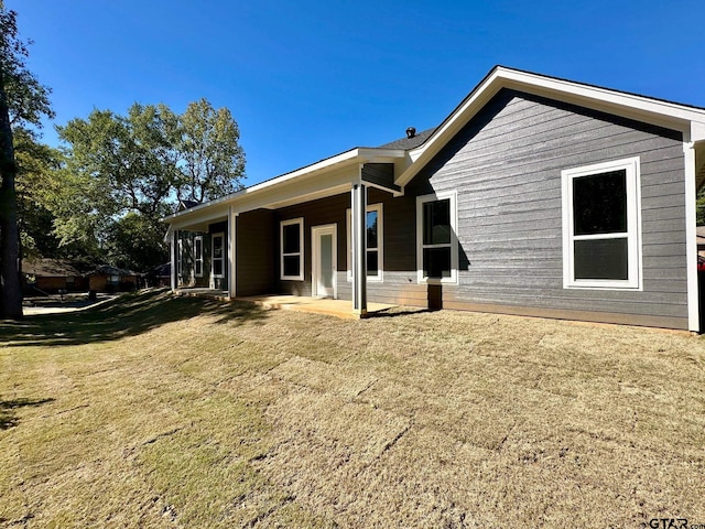 rear view of property with a lawn