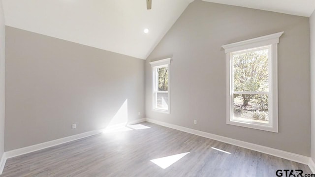 unfurnished room featuring high vaulted ceiling and light hardwood / wood-style flooring