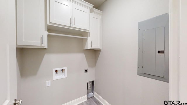 laundry room with hookup for an electric dryer, electric panel, light hardwood / wood-style floors, cabinets, and washer hookup