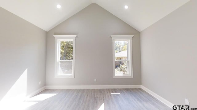 unfurnished room featuring high vaulted ceiling and light hardwood / wood-style floors