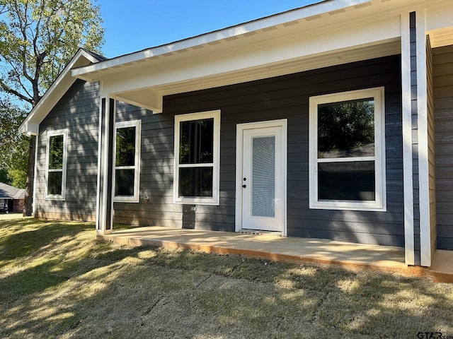 doorway to property with a lawn