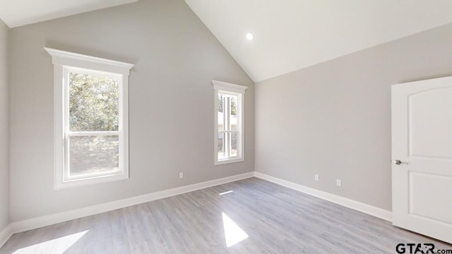 unfurnished room featuring light hardwood / wood-style floors and high vaulted ceiling