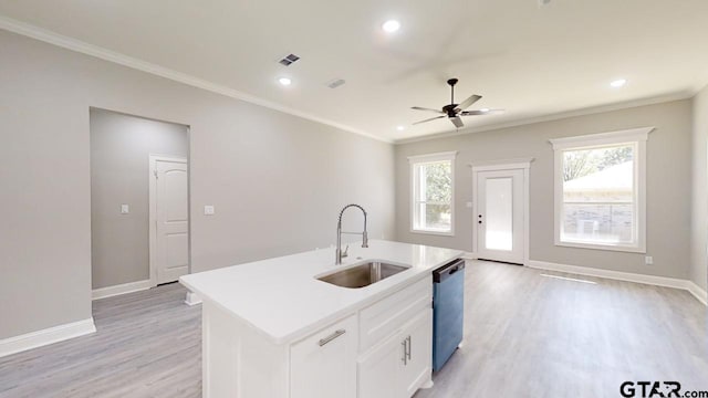 kitchen featuring a healthy amount of sunlight, white cabinetry, sink, and an island with sink