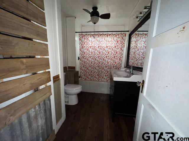 bathroom featuring ceiling fan, hardwood / wood-style floors, vanity, and toilet