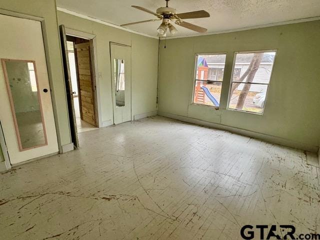 empty room featuring ceiling fan and a textured ceiling