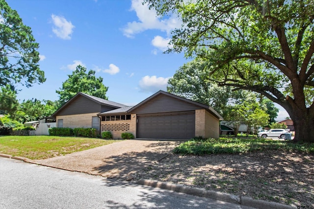 view of front of home featuring a garage, a front yard, concrete driveway, and brick siding