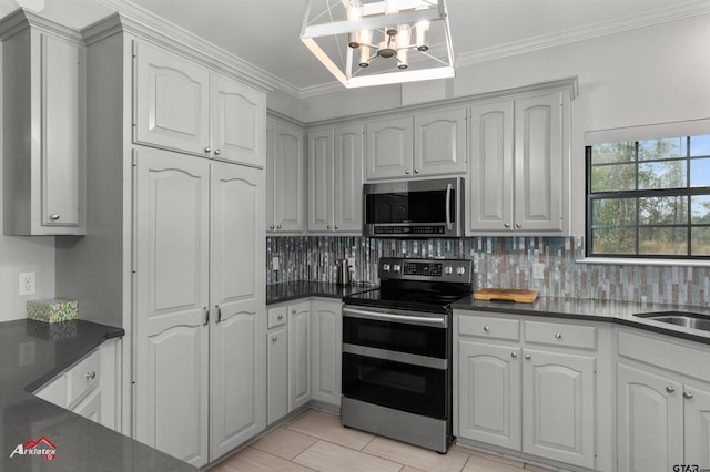 kitchen featuring sink, a notable chandelier, backsplash, crown molding, and appliances with stainless steel finishes