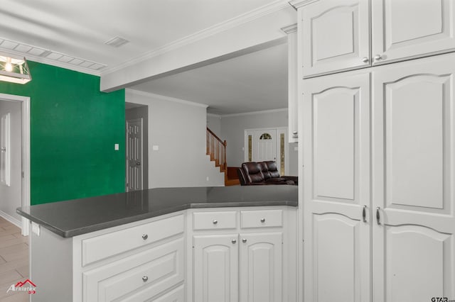 kitchen with white cabinets, kitchen peninsula, light hardwood / wood-style flooring, and ornamental molding