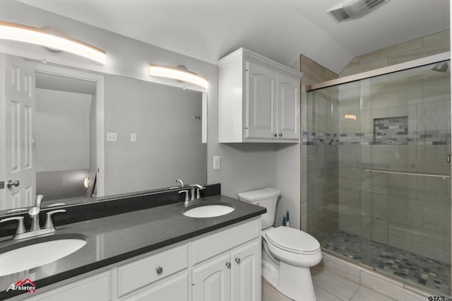 bathroom featuring tile patterned flooring, vaulted ceiling, toilet, a shower with door, and vanity