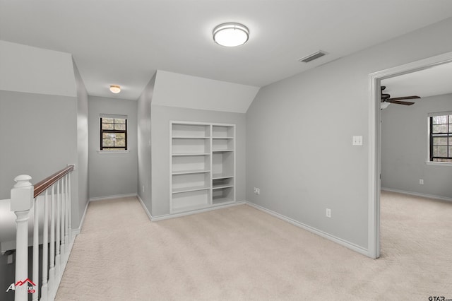 interior space with ceiling fan, light colored carpet, and lofted ceiling