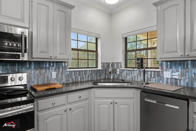 kitchen with backsplash, sink, white cabinets, and appliances with stainless steel finishes