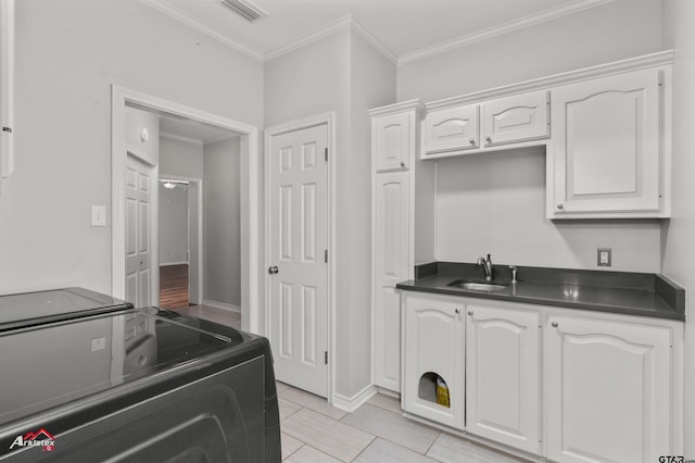 kitchen featuring white cabinetry, sink, and ornamental molding