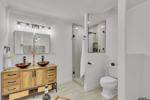 bathroom with crown molding, hardwood / wood-style flooring, a shower with door, vanity, and toilet