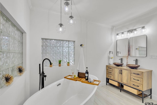 bathroom with vanity, ornamental molding, and a tub