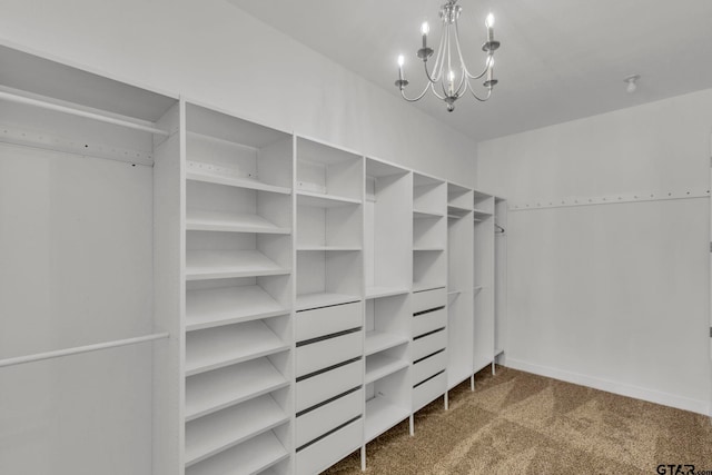 spacious closet featuring a notable chandelier and carpet