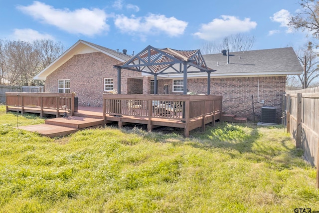 back of property with a wooden deck, a yard, and central AC