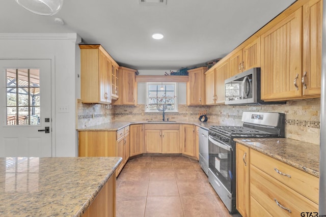 kitchen with light tile patterned flooring, light stone counters, appliances with stainless steel finishes, ornamental molding, and decorative backsplash