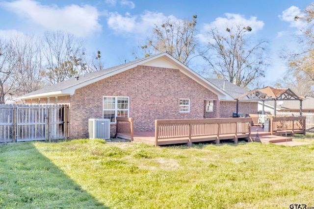 rear view of house featuring cooling unit, a gazebo, a lawn, and a deck