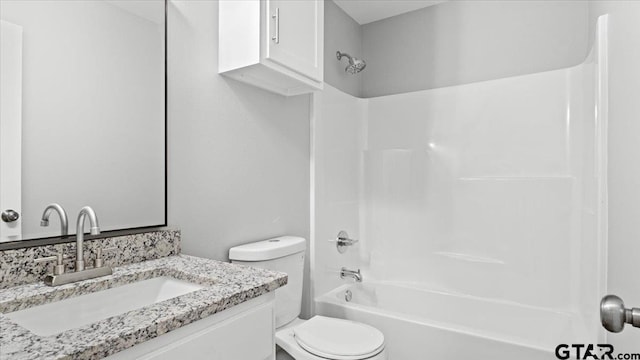 bathroom with toilet, vanity, and shower / tub combination