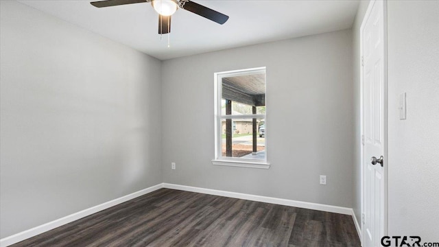 empty room featuring baseboards, a ceiling fan, and dark wood-style flooring